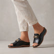Black FJØRNA orthopedic peep-toe chain link wedge sandals for women, featuring a stylish open-toe design and chunky wedge heel.