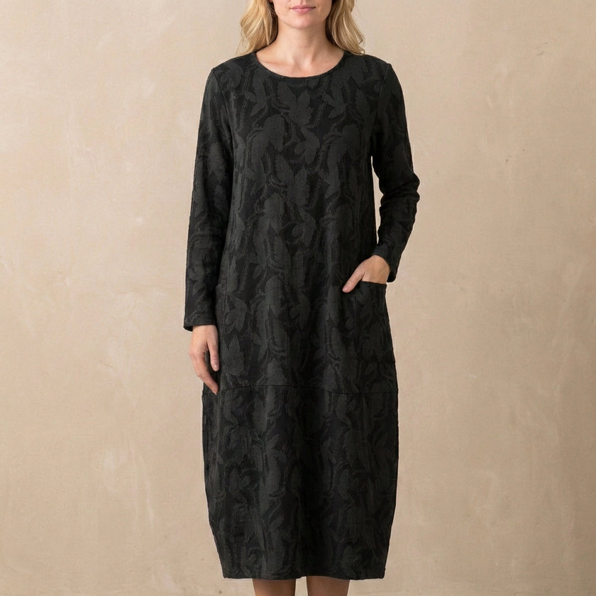 Black FJØRNA relaxed knit maxi dress with textured pattern and patch pockets, flowing and comfortable for casual wear.