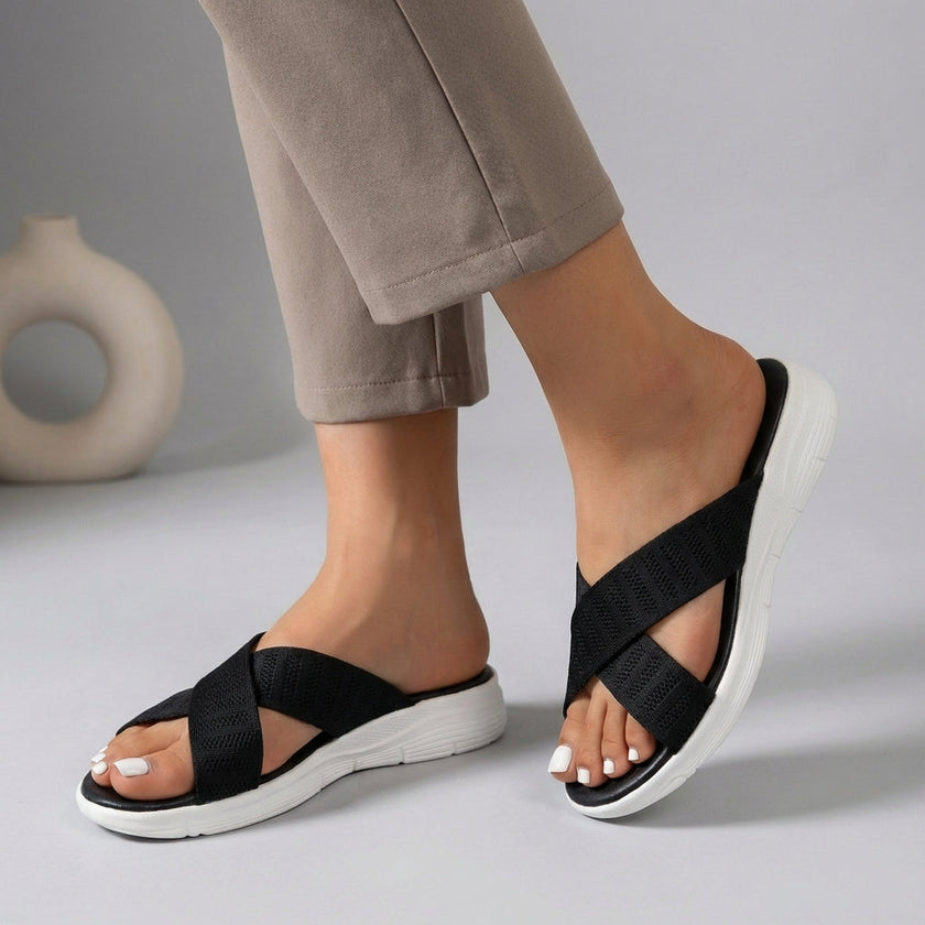 Black women's orthopedic sandals with adjustable criss-cross straps by FJØRNA, featuring supportive soles for comfort.