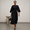 Black FJØRNA batwing sleeve wrap front belted maxi dress with slit, featuring flowing fabric and elegant design.