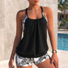Black women's summer swimsuit with halter neck and flowy design by FJØRNA, perfect for beach and poolside wear.