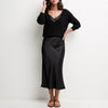 FJØRNA black relaxed V-neck knit top and satin maxi skirt set, showcasing the stylish two-piece ensemble with a comfortable fit.