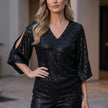 Black FJØRNA summer blouse for women with a V-neck and sequin details, stylish top for warm weather occasions.