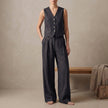 FJØRNA black tailored linen sleeveless vest with high-waisted pleated trousers, stylish 2-piece linen set on a model.