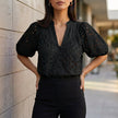 Black FJØRNA women's summer blouse with V-neck, linen fabric, button front, casual style, perfect for warm weather.