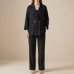 FJØRNA black 2-piece blazer and wide-leg trouser set on a model, showcasing relaxed fit and sophisticated style.