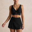 Black FJØRNA women's summer bikini with V-neck cut-out and adjustable straps, perfect for stylish beachwear.