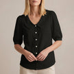 Black women's summer blouse with puff sleeves, linen fabric, and button-front design by FJØRNA.