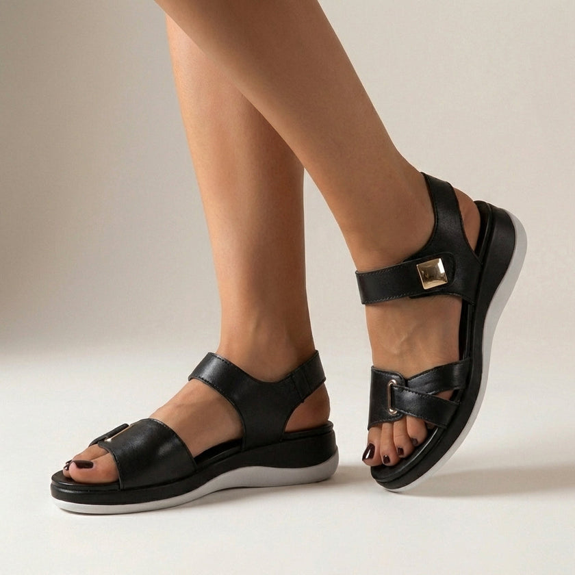 Black FJØRNA orthopedic platform strap sandals with buckle detail, showcasing comfortable footbed and stylish design.