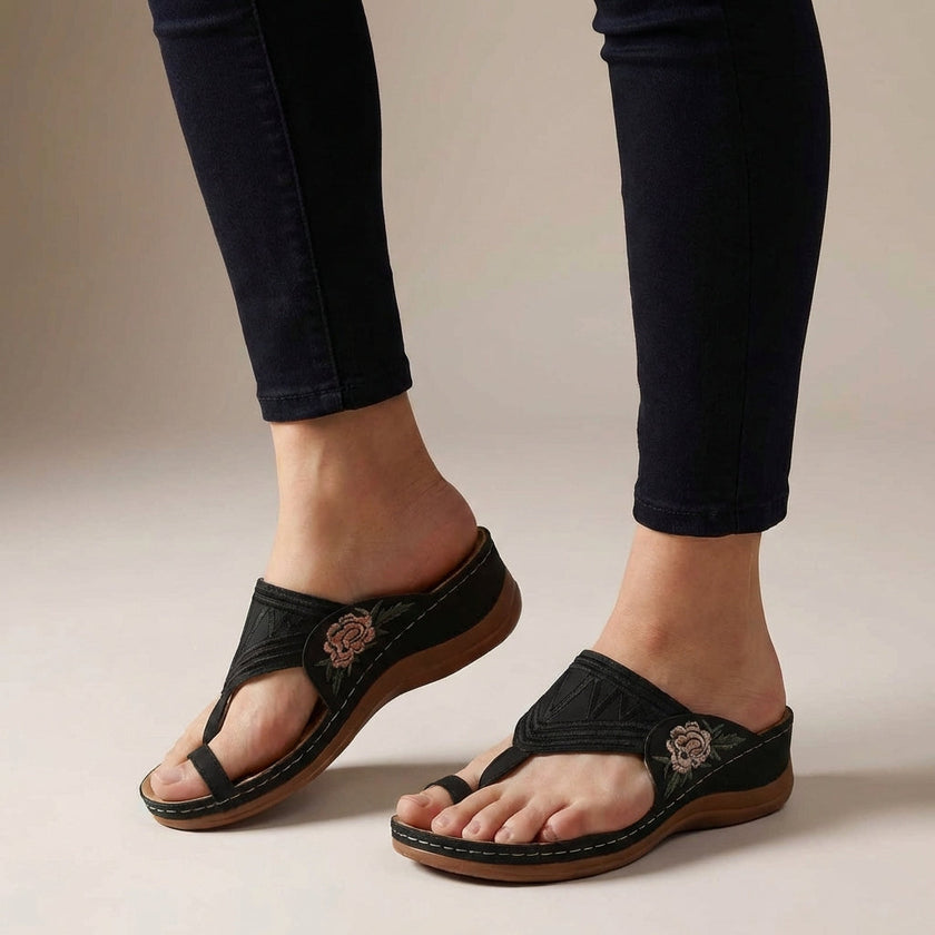 Black FJØRNA orthopedic floral embroidered wedge sandals for women with supportive design and decorative flower embroidery.