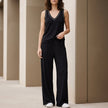 FJØRNA black sleeveless lounge set with relaxed V-neck top and wide-leg pants, comfortable 2-piece sleepwear ensemble.