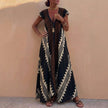 Black FJØRNA bohemian-inspired flowing A-line maxi dress with deep V-neck and geometric motifs, showcasing a relaxed, elegant style.