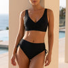 Black FJØRNA wrap V-neck bikini top with ruched side-tie high-waist bottoms, perfect for stylish women’s swimwear.