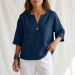 Blue women's summer blouse by FJØRNA with V-neck, linen fabric, and button front, perfect for warm weather.