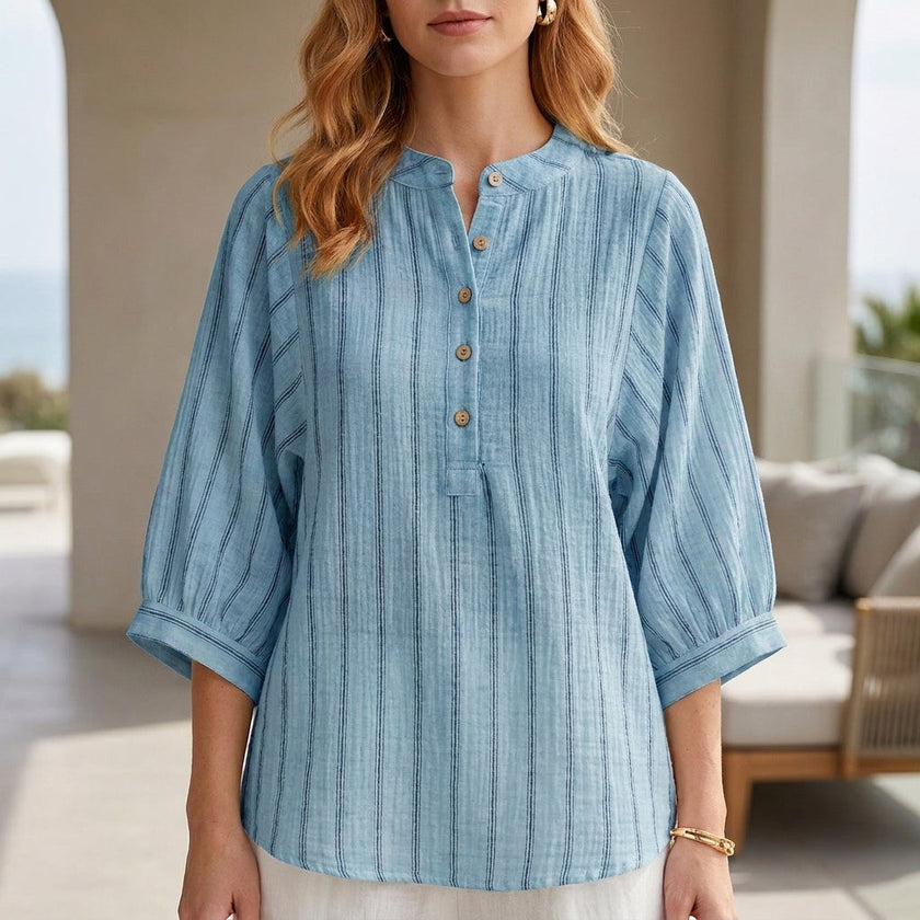 Blue striped linen summer blouse for women by FJØRNA featuring button front and relaxed fit, shown on a model.