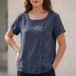 Blue women's linen blouse by FJØRNA with relaxed fit and asymmetric detail, ideal for casual daywear.