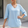 Blue women's V-neck blouse by FJØRNA featuring a flowing fit, curved hem, and slit sleeves.