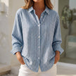 Blue striped button-down blouse for women by FJØRNA featuring cuffed sleeves and a relaxed fit top.