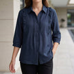 Blue denim ruffle summer blouse for women from FJØRNA, featuring a stylish, lightweight top with feminine ruffle details.
