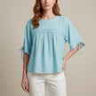 Blue linen flowy summer blouse for women by FJØRNA, featuring a relaxed fit and lightweight fabric, perfect for warm weather.