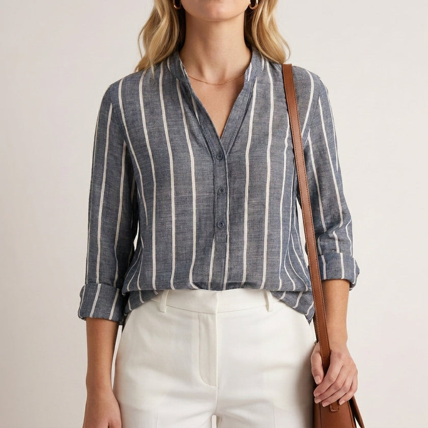 Blue striped women's summer blouse by FJØRNA with long sleeves and button front, shown on a model.
