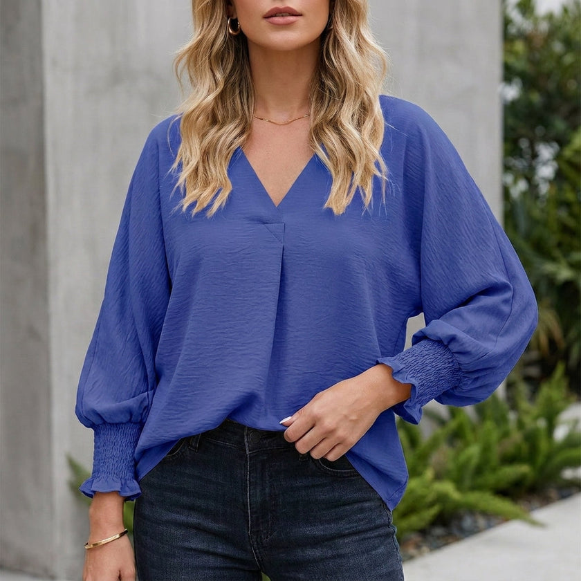 Blue FJØRNA summer women's V-neck denim blouse with ruffle trim, lightweight and stylish for warm weather.