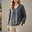 Blue FJØRNA women's summer blouse with V-neck, linen fabric, and slit detail, perfect for warm weather casual wear.