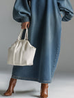 Blue denim maxi dress by FJØRNA, flowing evening dress with a relaxed fit and long length, displayed on a hanger.
