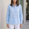 Blue linen summer blouse for women with button-front design by FJØRNA, styled as a casual, breathable top.