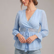 Blue FJØRNA women's summer blouse with V-neck and ruffle details, made from lightweight linen fabric.