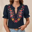 Blue floral summer blouse for women by FJØRNA with puff sleeves and ruffle details, shown on a model.