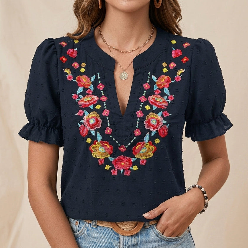 Blue floral summer blouse for women by FJØRNA with puff sleeves and ruffle details, shown on a model.