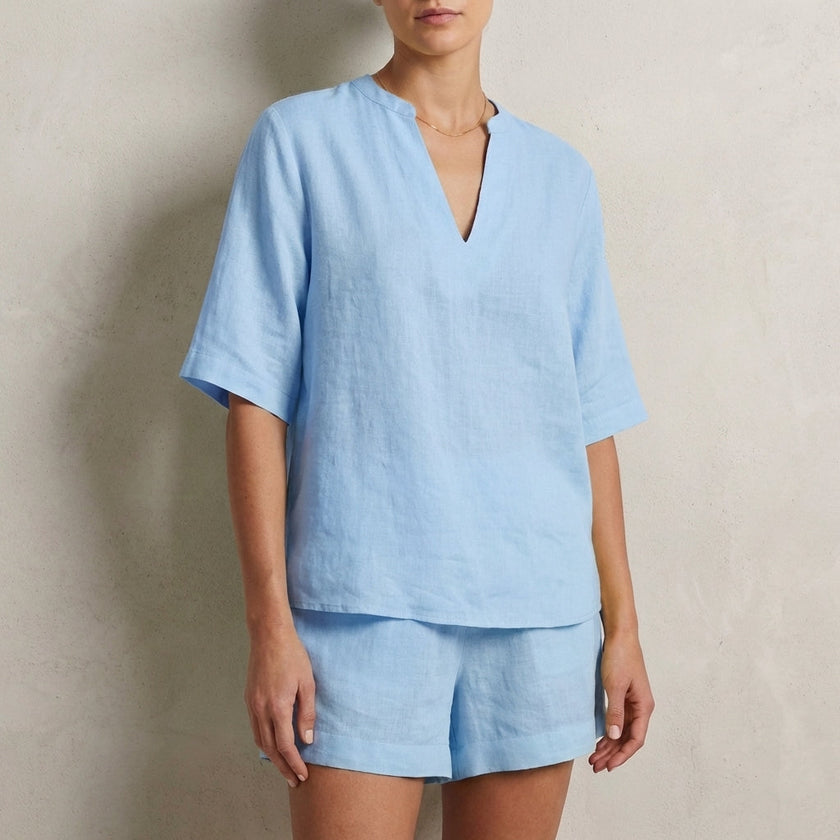 Blue women's summer two-piece co-ord set by FJØRNA featuring V-neck top with pockets and matching shorts.
