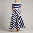 Blue FJØRNA A-line striped maxi dress with pockets for women, showing the flowing fabric and stylish design.