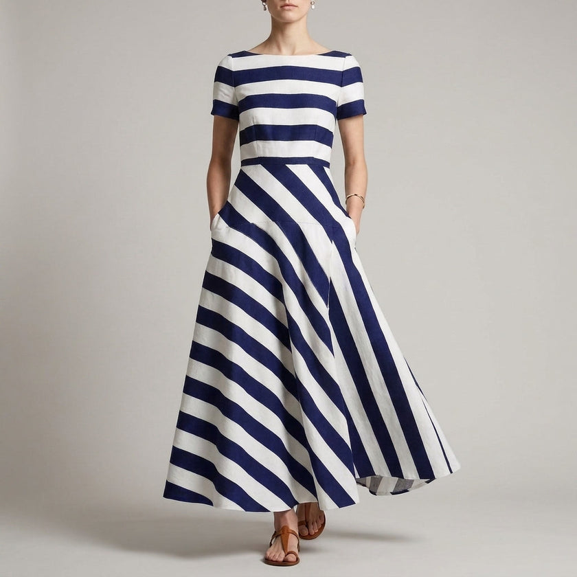 Blue FJØRNA A-line striped maxi dress with pockets for women, showing the flowing fabric and stylish design.