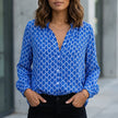 Blue women's summer blouse with geometric V-neck and long sleeves from FJØRNA, stylish and lightweight for warm weather.