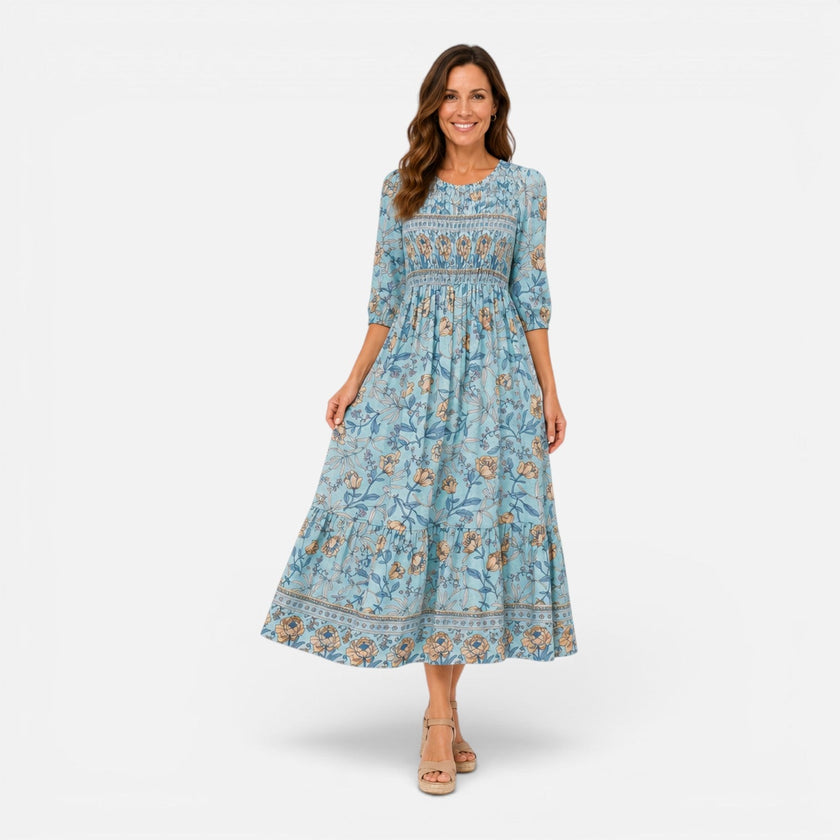 Women's floral midi dress for summer, casual style by FJØRNA, featuring a vibrant print and flowing fabric.
