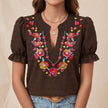 FJØRNA women's summer blouse with floral print, puff sleeves, and ruffle details in brown fabric.