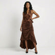 FJØRNA satin halter neck maxi dress in brown with bow tie waist and ruffled hem, showcasing elegant, flowing design.