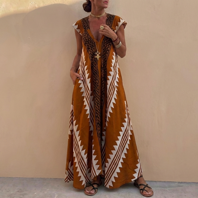 FJØRNA bohemian-inspired flowing brown A-line maxi dress with deep V-neck and geometric motifs, loose fit and elegant design.