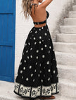 Black printed halter flowy maxi dress by FJØRNA featuring a relaxed fit and elegant design.