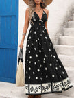 FJØRNA printed halter flowy maxi dress in white with black floral pattern, elegant sleeveless dress with a flowing silhouette.