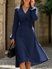 White FJØRNA V-neck lantern long-sleeved dress with a flowy silhouette, shown on a model against a neutral background.