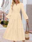 FJØRNA white V-neck pleated waist tiered long-sleeved dress displayed on a mannequin, showcasing elegant design and flowing fabric.