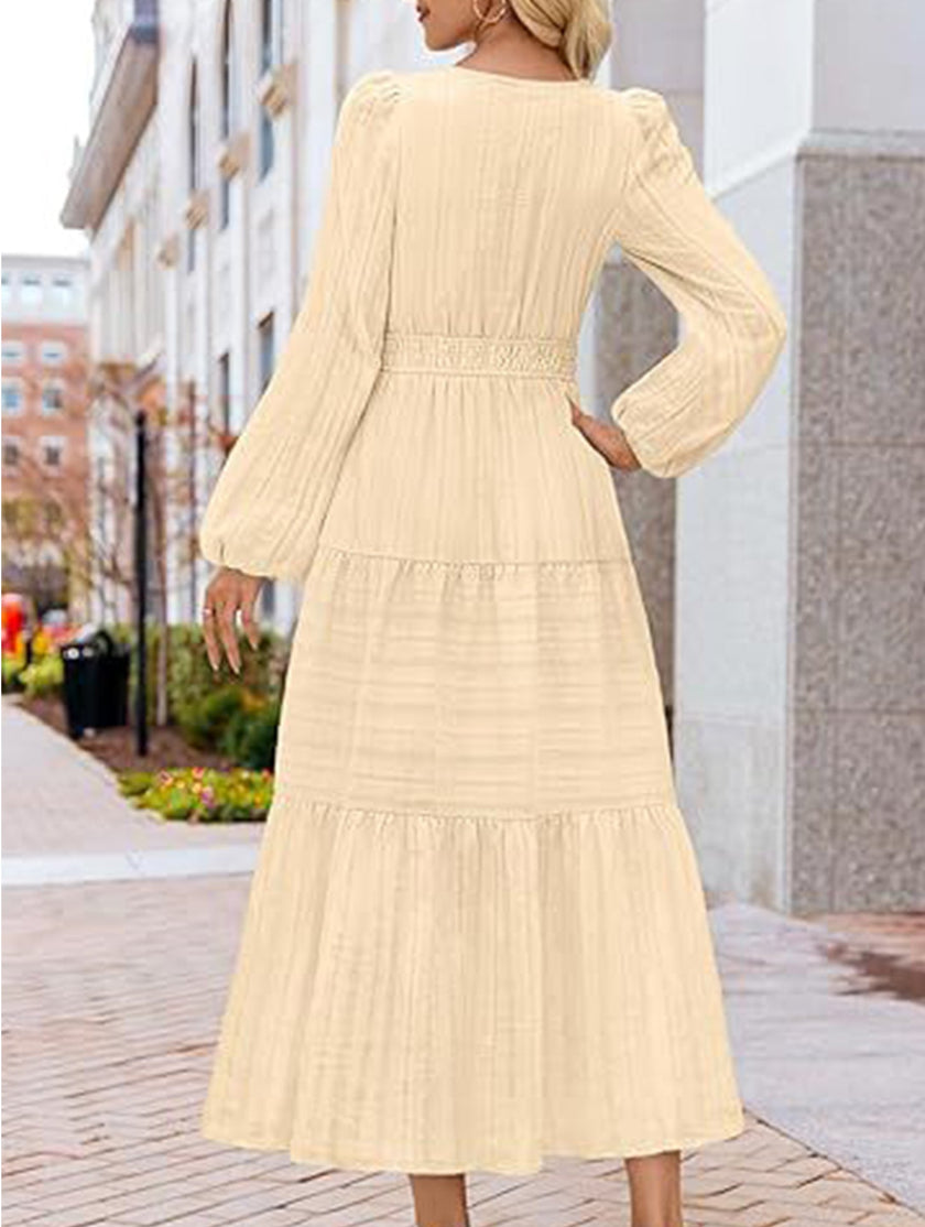 FJØRNA white V-neck pleated waist tiered long-sleeved dress with a flowing silhouette and elegant design.