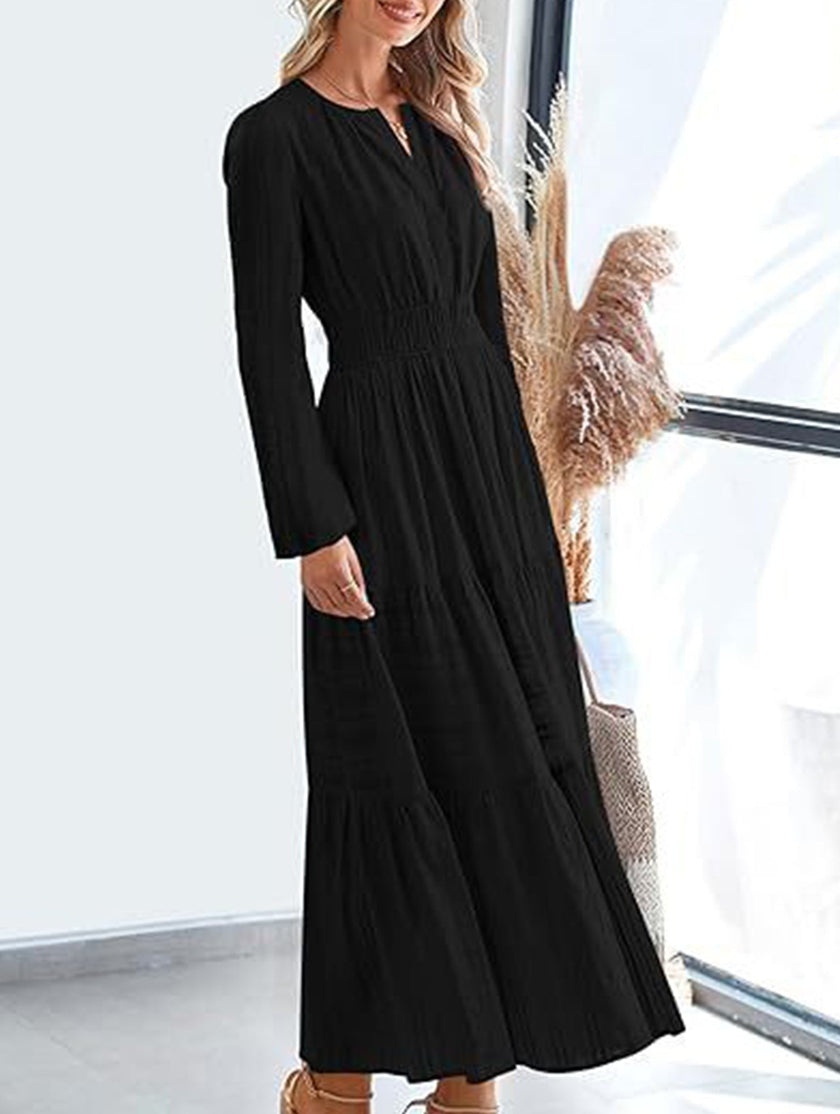 FJØRNA black V-neck pleated waist tiered long-sleeved dress, featuring a flowing design and feminine silhouette.