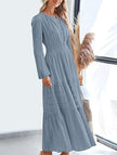 FJØRNA V-neck pleated waist tiered long-sleeved dress in white, featuring flowing fabric and tiered design, shown on a model.