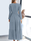 FJØRNA white V-neck pleated waist tiered long-sleeved dress, showcasing a flowing fabric and elegant design.