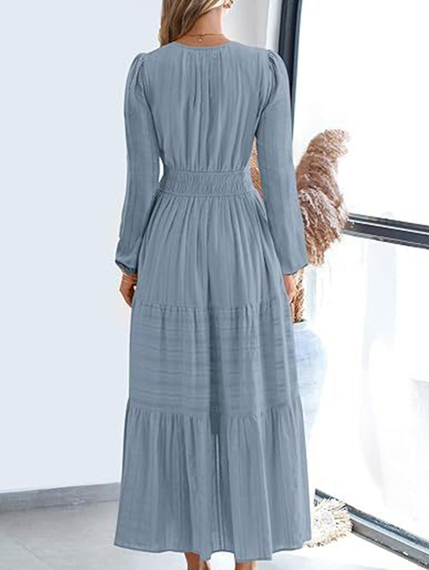 FJØRNA white V-neck pleated waist tiered long-sleeved dress, showcasing a flowing fabric and elegant design.
