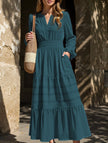 White V-neck pleated waist tiered long-sleeved dress by FJØRNA, showing the flowing fabric and elegant design.